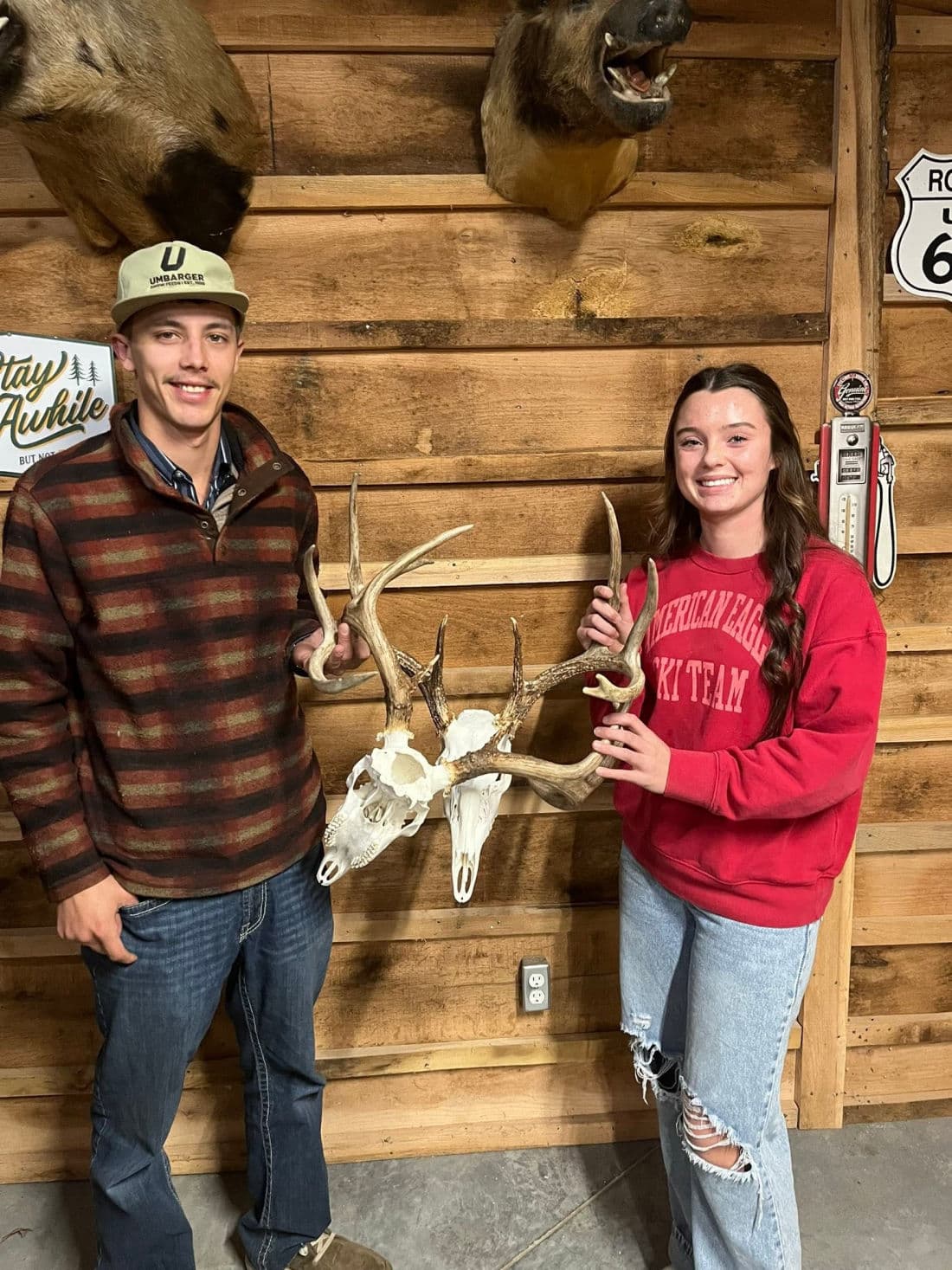 Two customers at the shop holding a pair of finished European skull mounts